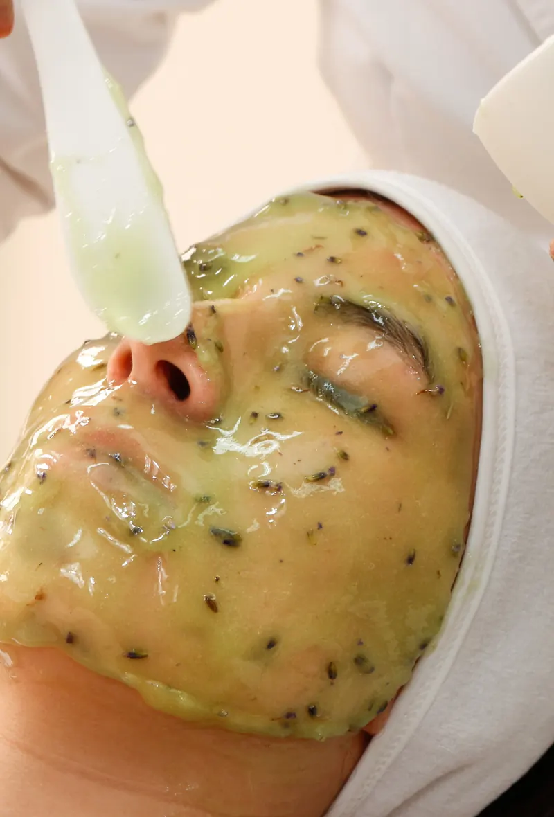 Applying a green esthemax® mask with a brush in the treatment room